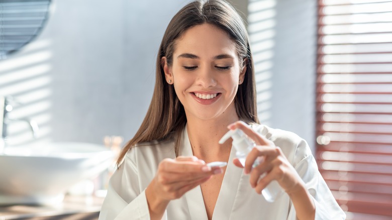 Woman applying makeup remover on cotton pad