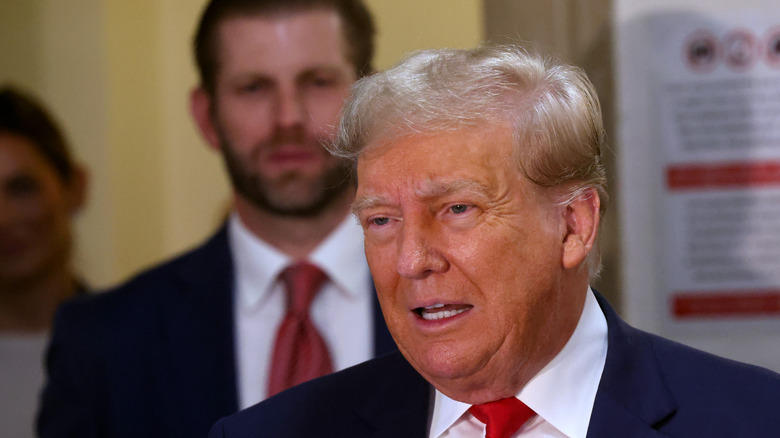 Donald Trump talking with Eric Trump looking on