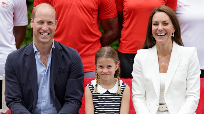 Prince William, Princess Charlotte and Catherine Middleton smiling at an event