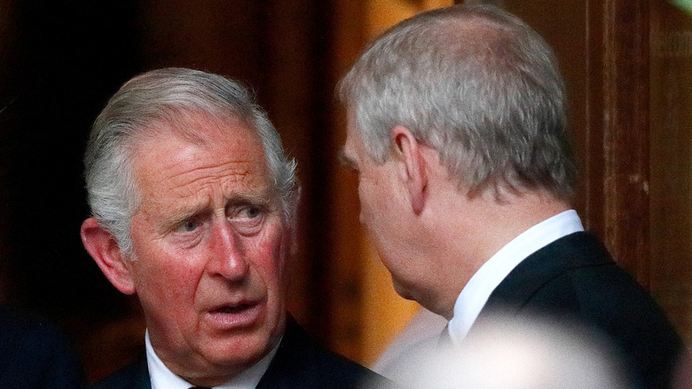 King Charles III looking at Prince Andrew