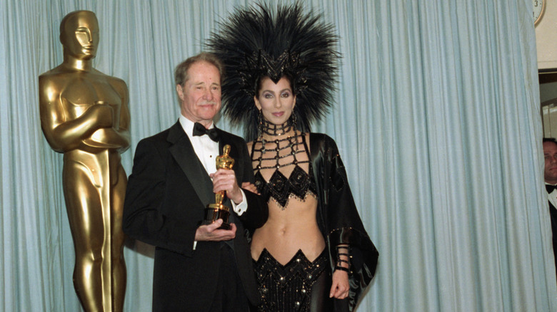 Don Ameche holding his Oscar and standing next to Cher