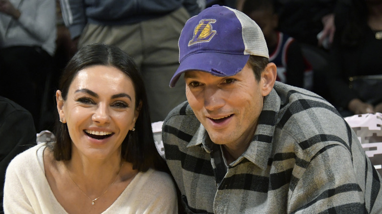 Mila Kunis and Ashton Kutcher smiling at an event