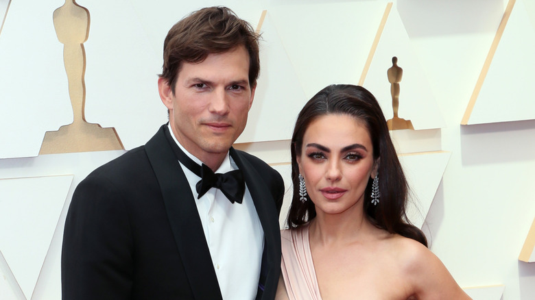 Ashton Kutcher and Mila Kunis posing for photos at the Oscars