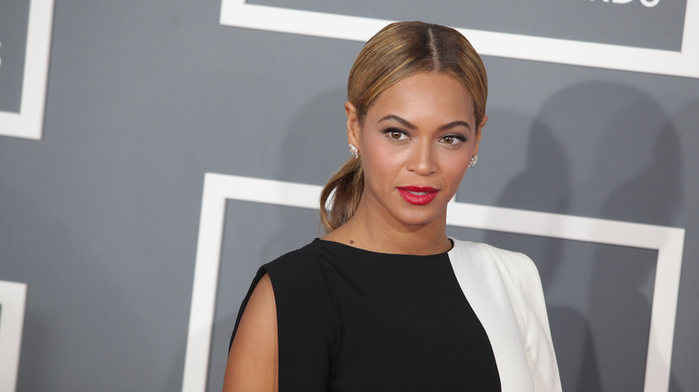 Beyoncé posing at an event in red lipstick