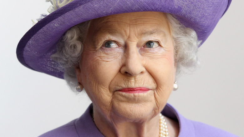 Queen Elizabeth purple hat and suit mischievous smile