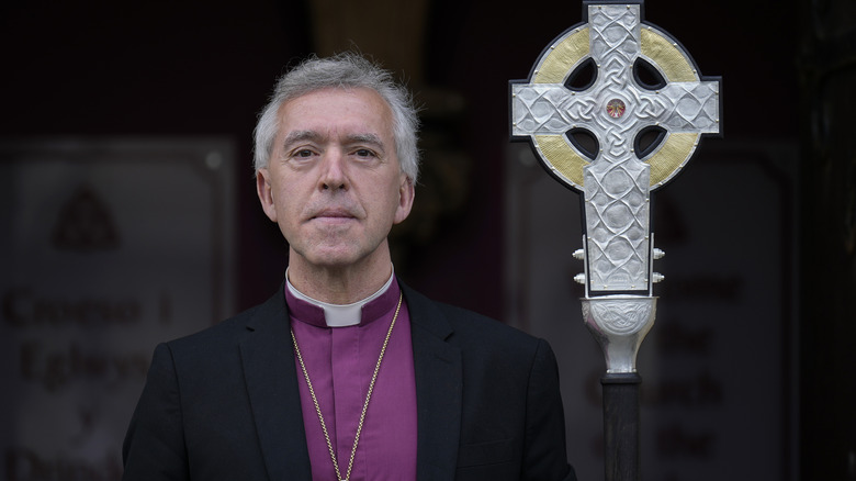 Priest posing with a cross