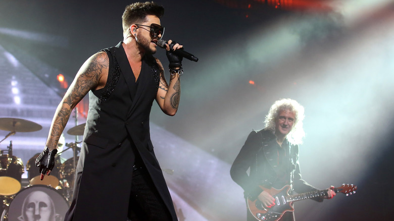 Adam Lambert performing on stage with Queen