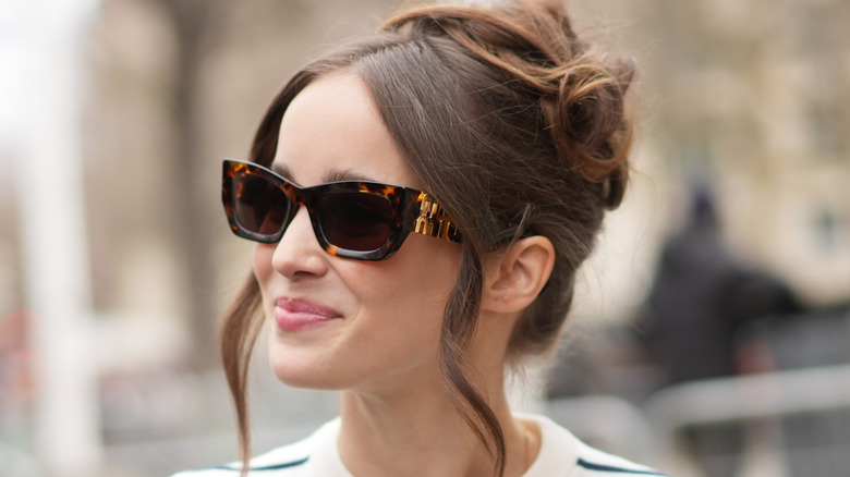 Alba Baptista smiling from behind sunglasses