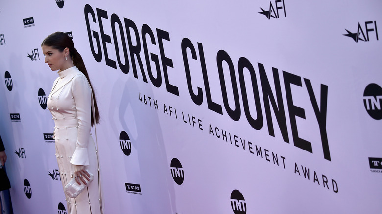 Anna Kendrick posing in front of George Clooney sign
