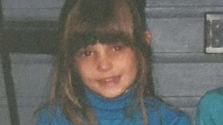 Ashley Greene as a child smiling towards the camera