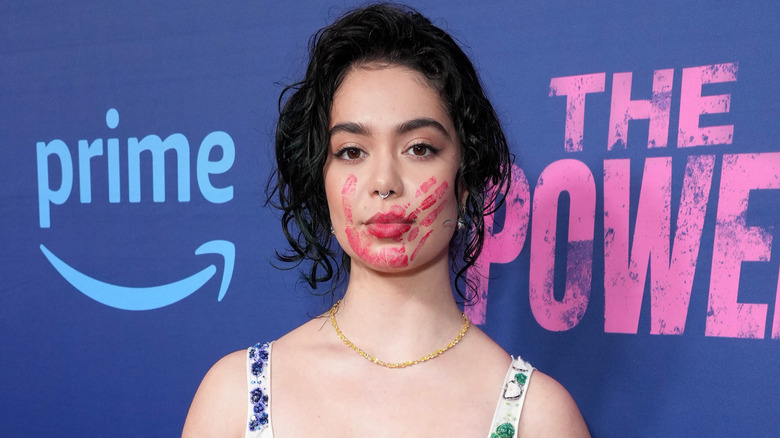 Auli'i Cravalho posing with a red handprint over her mouth