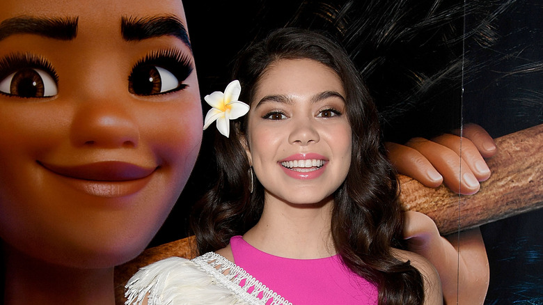 Auli'i Cravalho smiling with Moana backdrop