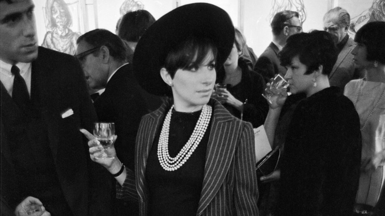 Barbra Streisand in a black hat and pearls