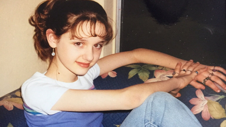 Laura Spencer sitting on a couch smiling