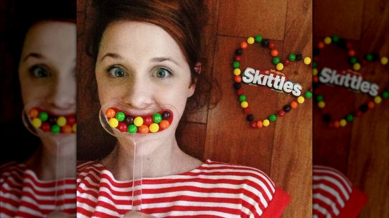 Laura Spencer holding dental mouthpiece full of Skittles