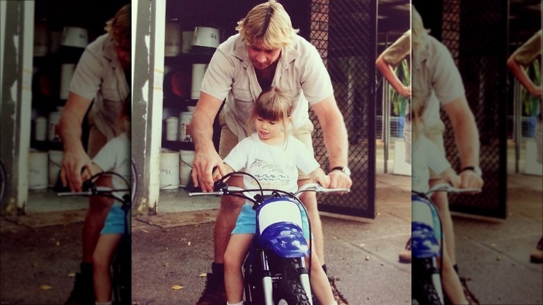 Bindi Irwin learning to ride a motorbike with her father