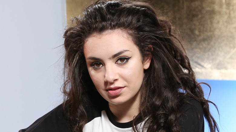 Charli XCX smiling with curly hair