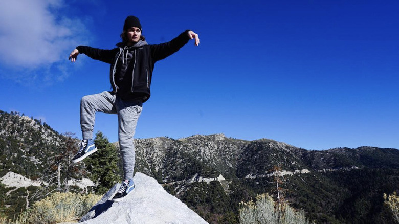 Chase Stokes posing on a rock