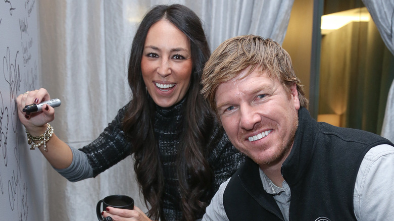 Chip and Joanna Gaines signing a wall