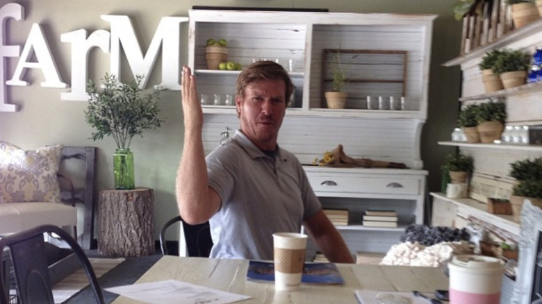 Chip Gaines in front of a hutch and home decor