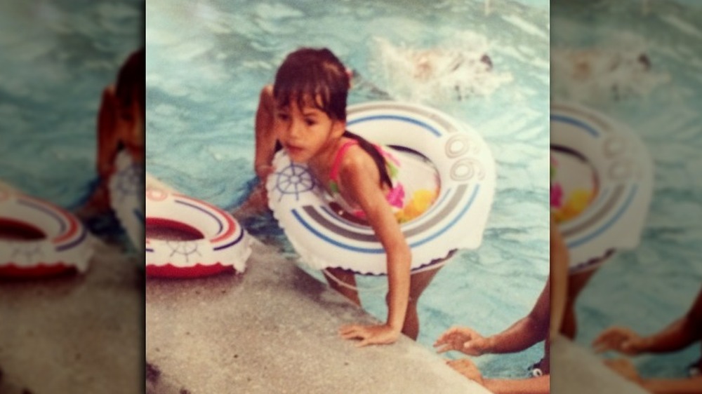 Chrissy Teigen as a young girl in an inner-tube