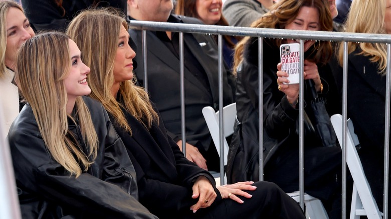 Coco Arquette and Jennifer Aniston sitting together and smiling