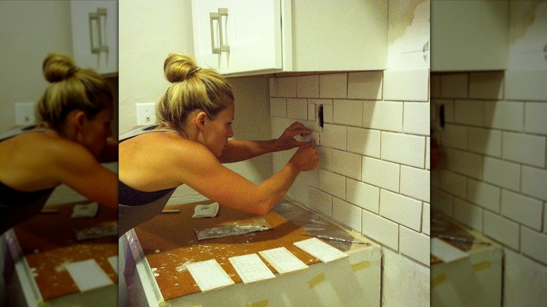 Cristy Lee laying backsplash tiles