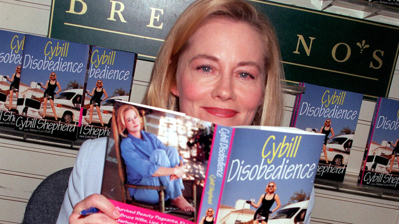 Cybill Shepherd holding copy of her book, Cybill Disobedience