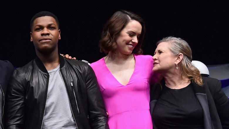 The cast of The Force Awakens, including Daisy Ridley and Carrie Fisher, on stage