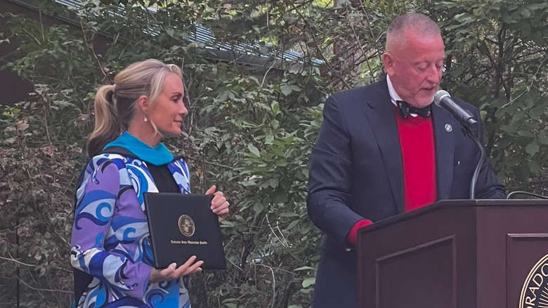 Dana Perino holding a diploma