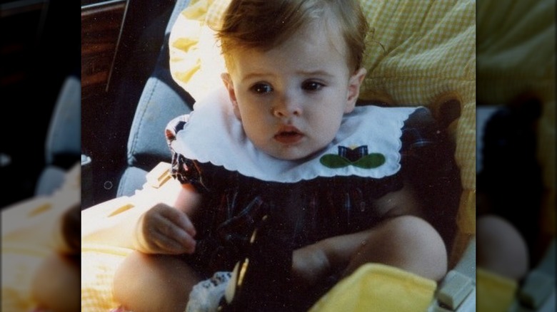 Danielle Panabaker as a baby riding in a car