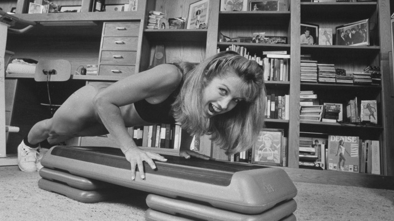 Young Denise Austin jumping in workout gear