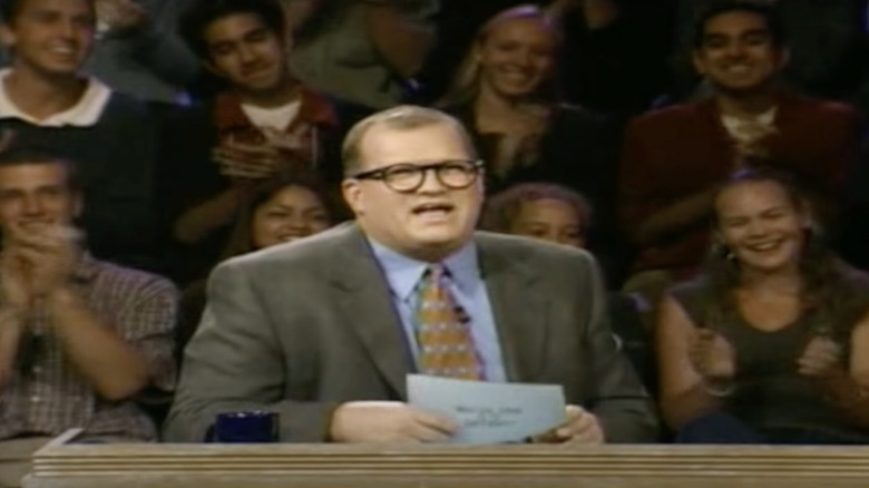 Drew Carey behind Whose Line desk