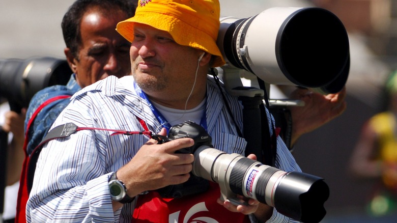 Drew Carey holding telephoto lens camera