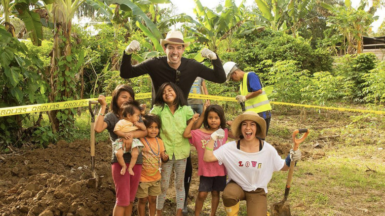 Linda Phan and Drew Scott posing with individuals they met during their trip to Ecuador