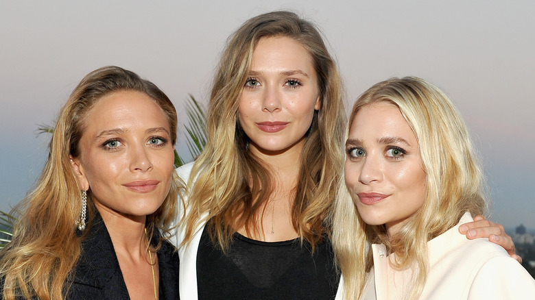 Elizabeth Olsen poses with sisters Mary-Kate and Ashley Olsen