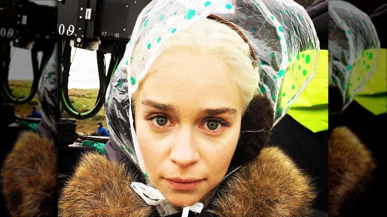 Emilia Clarke protecting her wig from rain