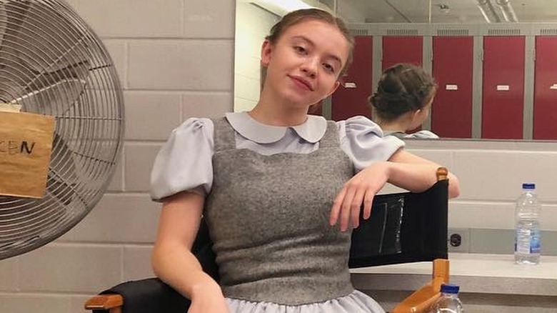 Sydney Sweeney sitting on set 