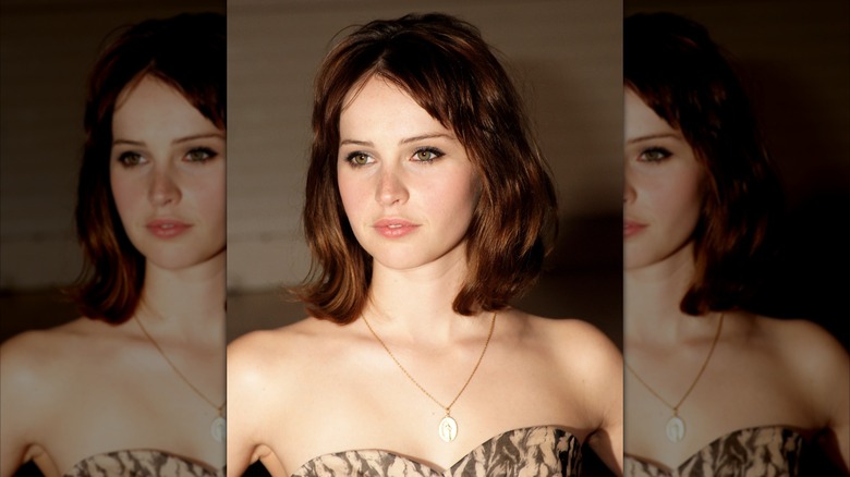 Felicity Jones with short hair standing in front of a brown backdrop in 2009