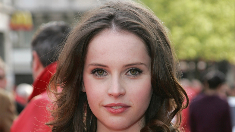 Felicity Jones smiling outside on the red carpet in 2008