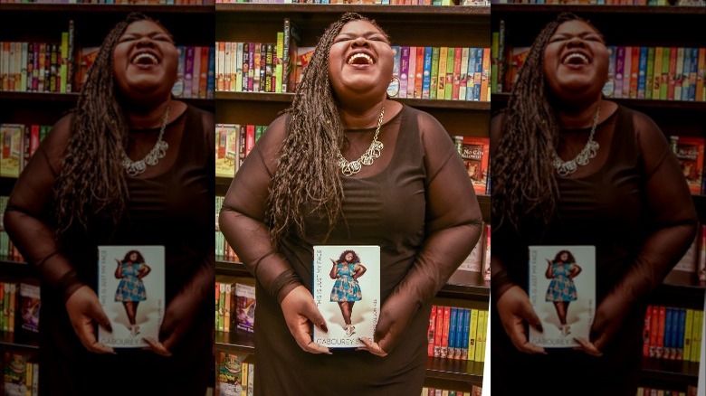 Gabourey Sidibe laughing holding her book