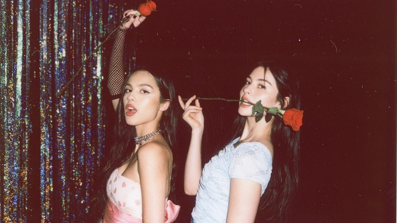 Olivia Rodrigo and Gracie Abrams posing with roses