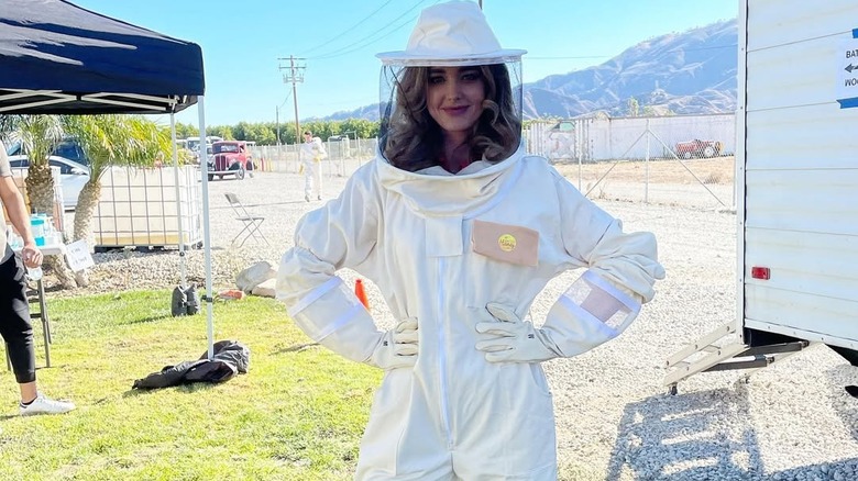 Ashley Newbrough wearing a white full-body beekeeper outfit