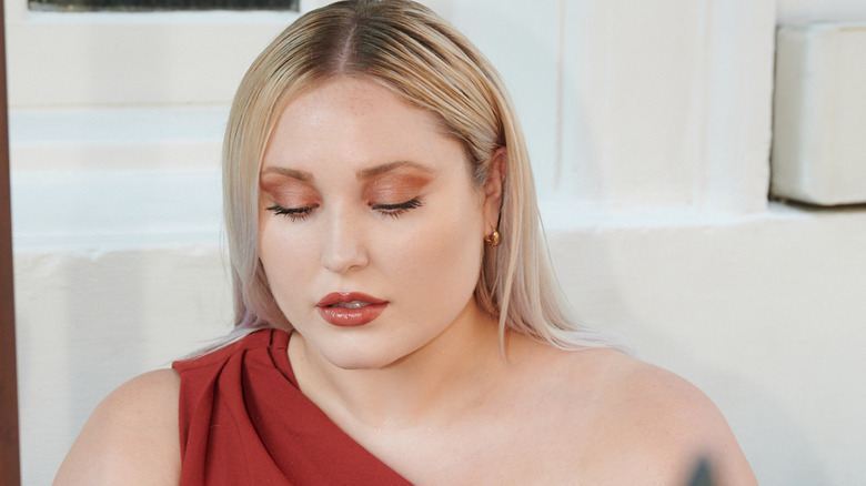 Hayley Hasselhoff in red dress looking down