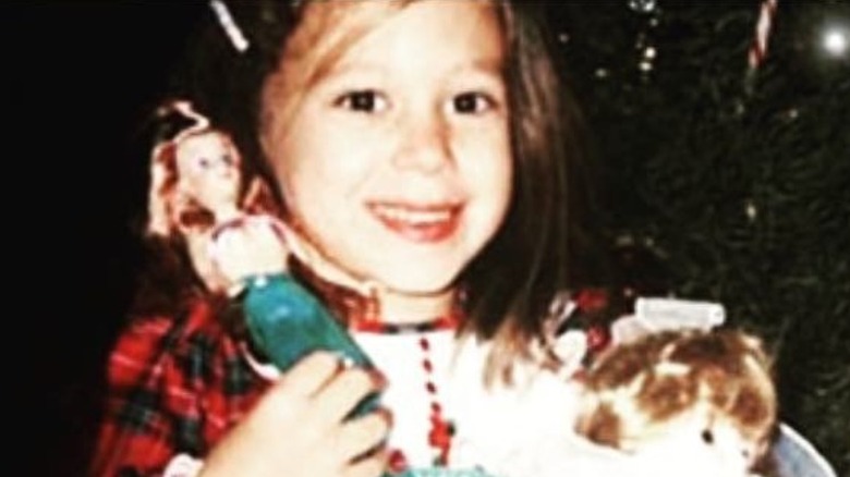 Haylie Duff holding dolls, smiling