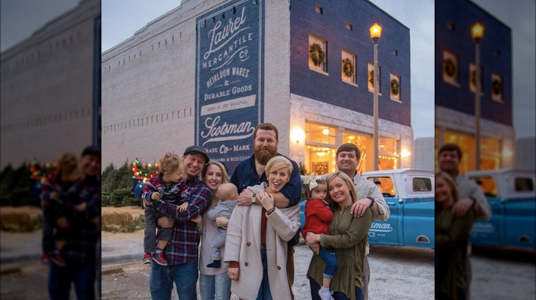 Erin and Ben Napier posing with friends in front of Laurel Mercantile