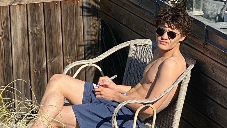 Jack Depp sitting, wearing sunglasses
