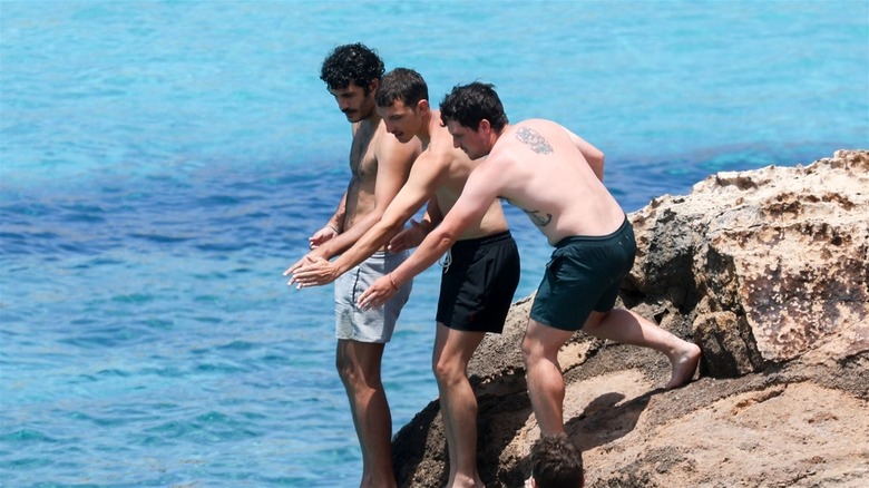 Shirtless Hutcherson and two friends on beach