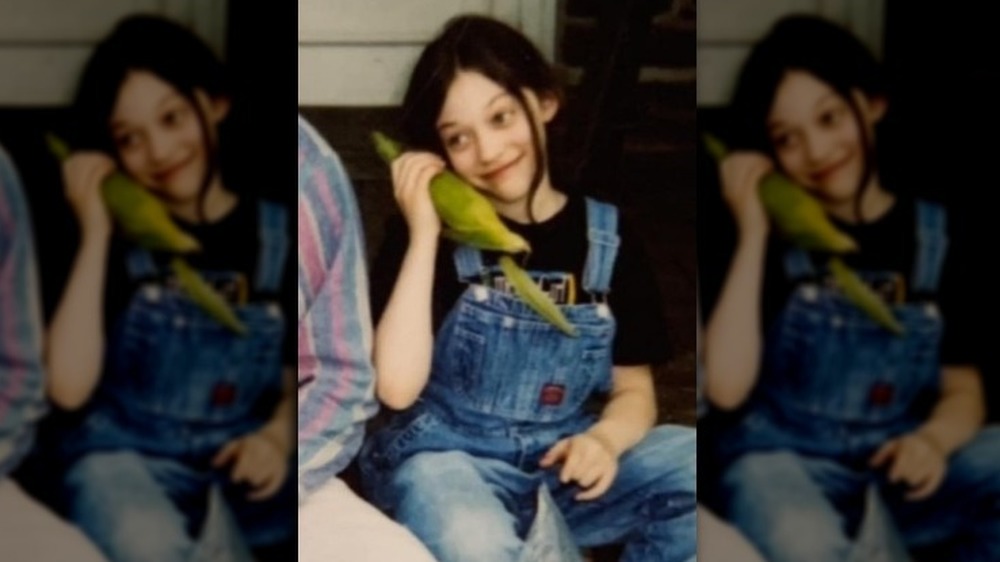 Young Kat Dennings with corn
