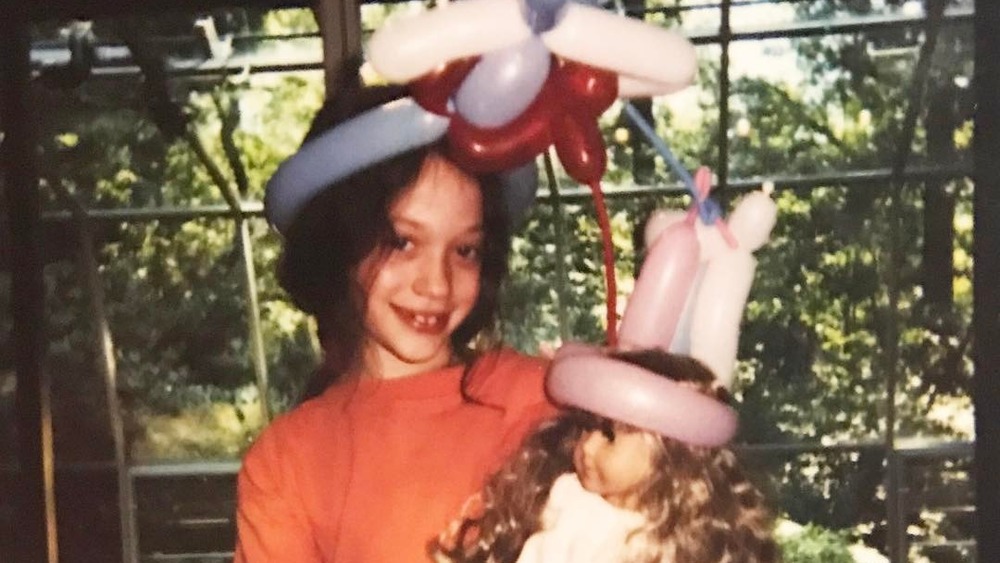 Young Kat Dennings with balloons